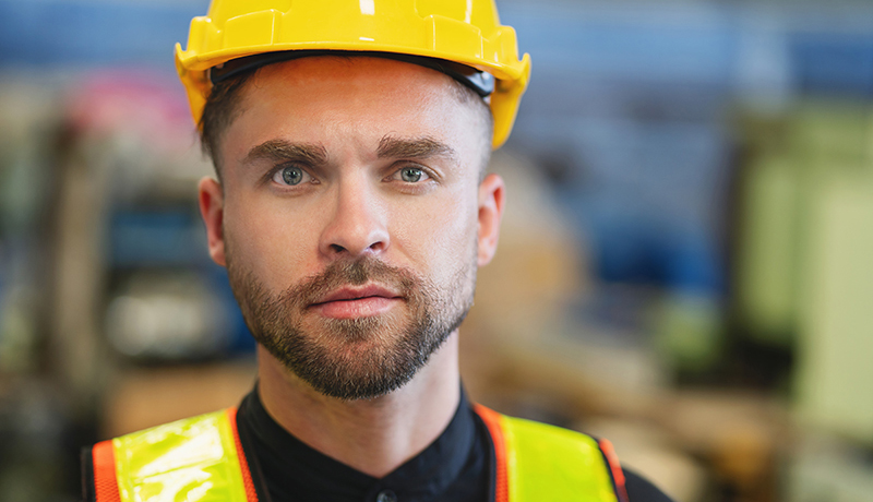 Ein Mann mit gelben Helm und Sicherheitsweste
